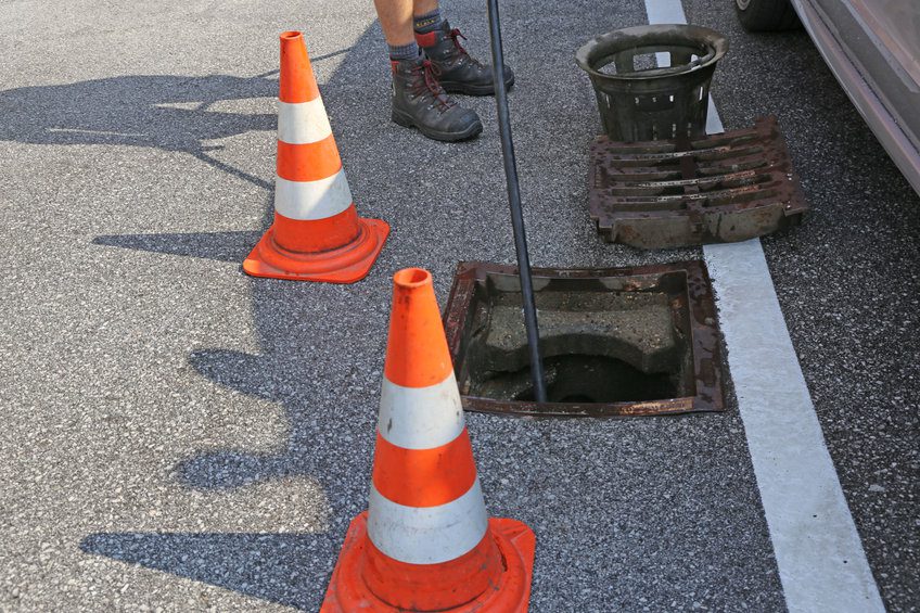plumber putting a camera into a sewer in order to do a pipeline assessment