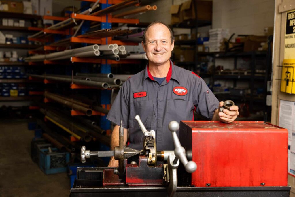 a Gotelli plumber working with equipment with pipes in the background