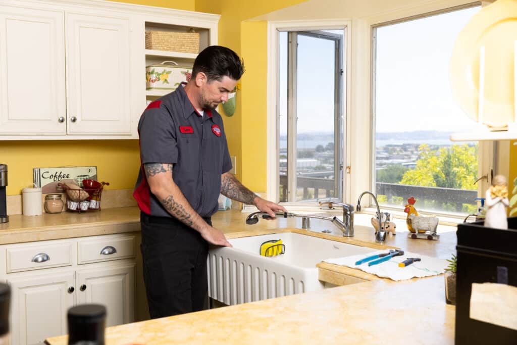 a Gotelli plumber investigating a problem with a kitchen sink