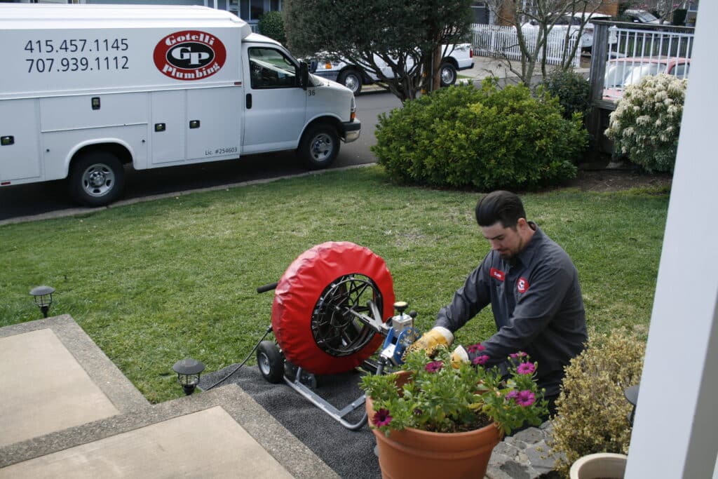a gotelli plumber kneeling outside to provide sump pump services for a San Rafael home