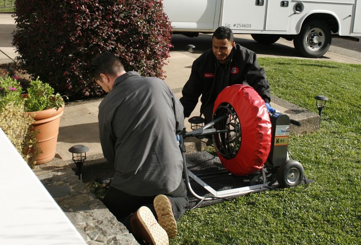 Two Gotelli plumbers running line into a sewer pipe